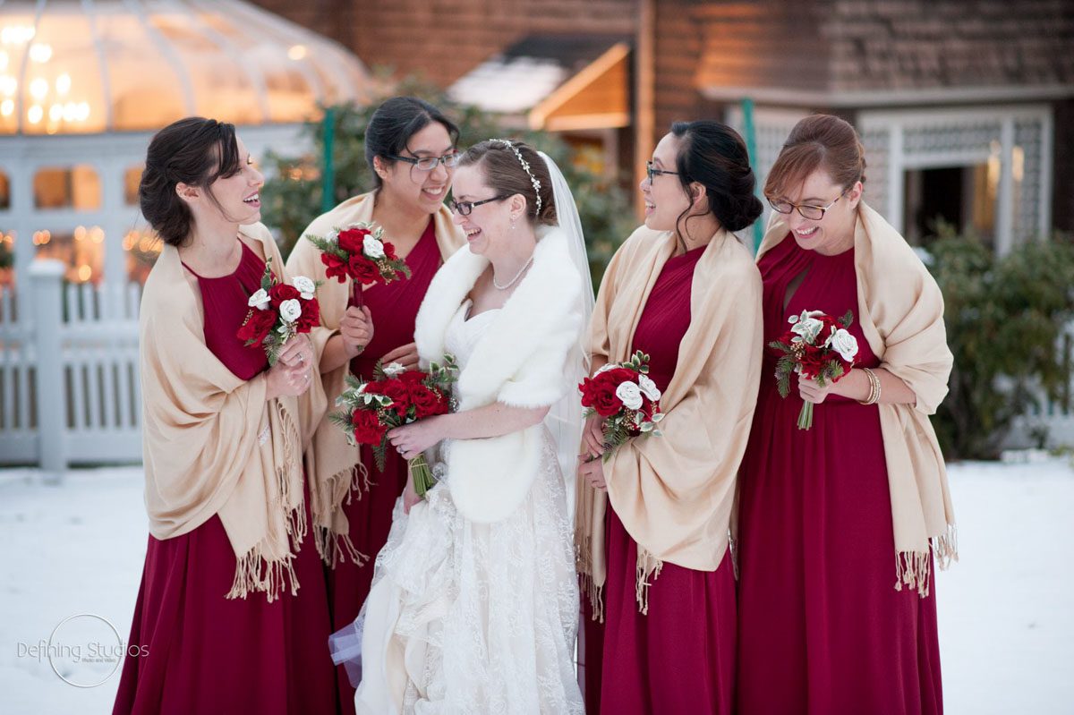 bride-bridesmaids-laughing-outside-in-snow-at-christmas-wedding