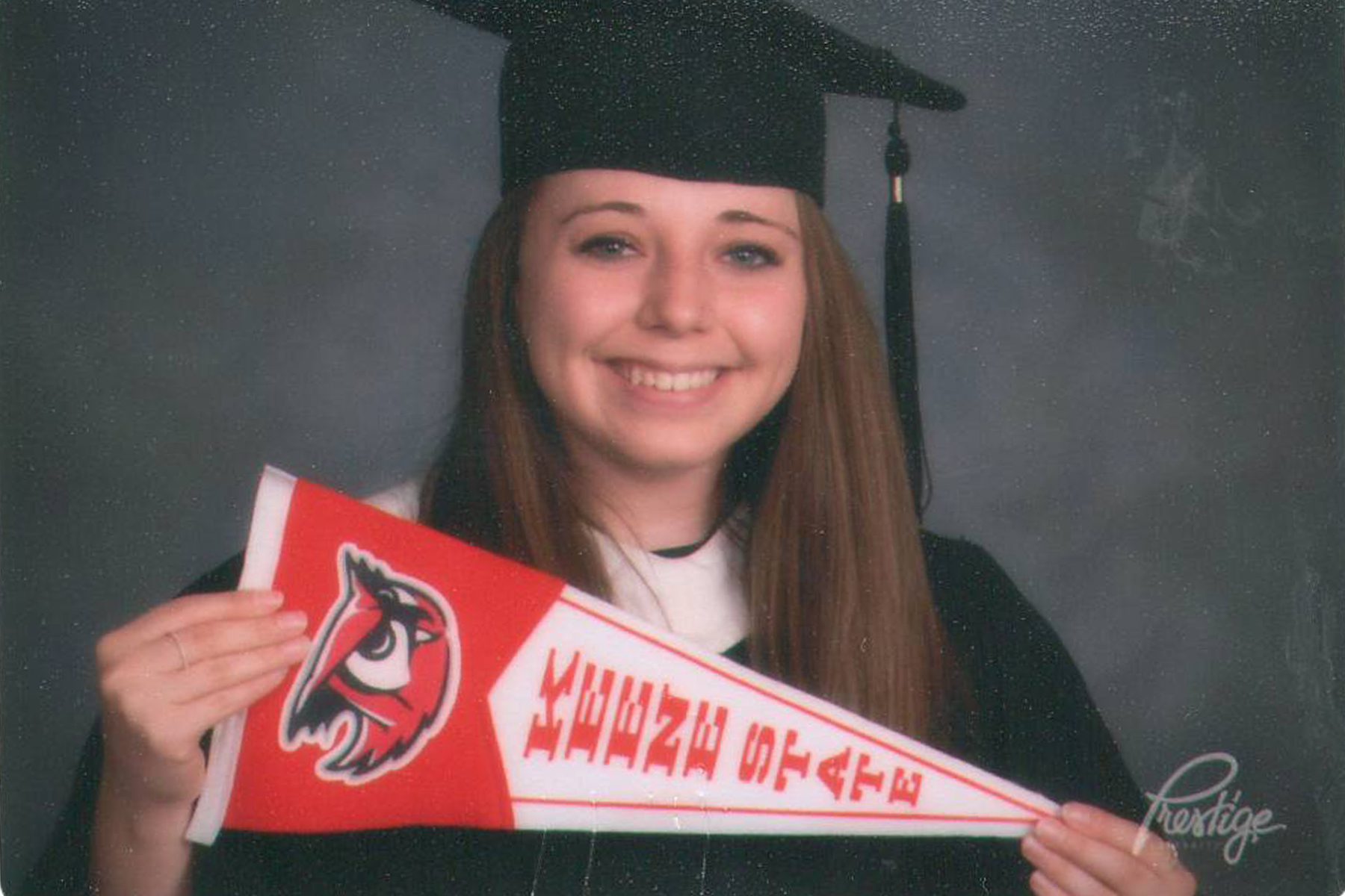 alexandra holding keene state pennant in cap and gown