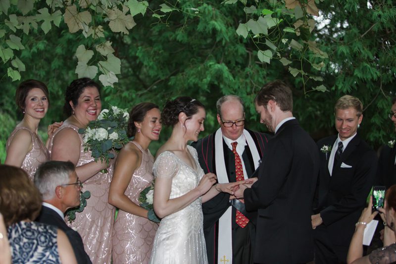 art-deco-wedding-couple-exchanging-rings-under-grape-arbor-ceremony