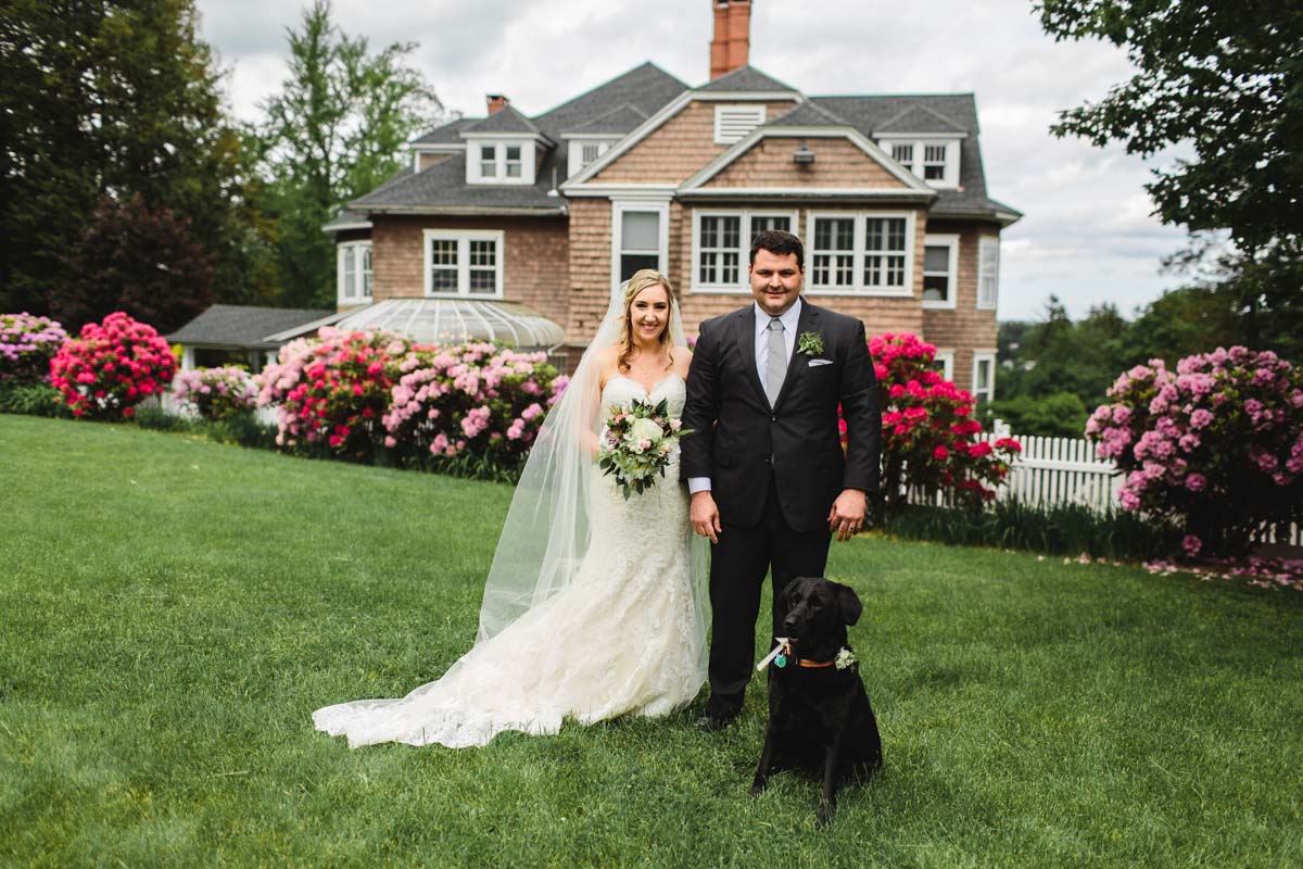 tent-reception-couple-standing-on-lawn-with-black-dog
