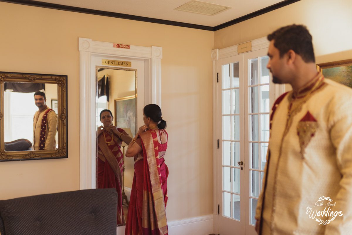 mom-looking-in-mirror-with-groom-looking-on-for_indian-wedding