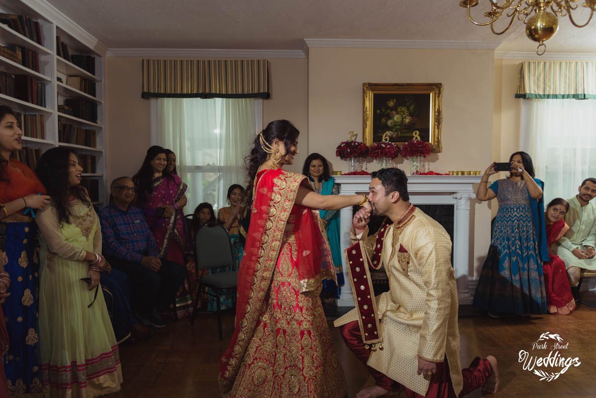 indian-groom-kneeling-before-indian-bride kissing-her-hand