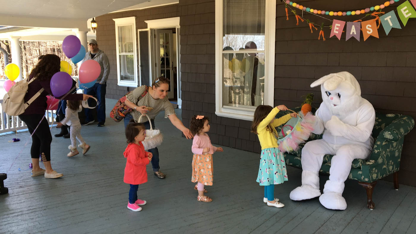 easter-bunny-sitting-on-couch-with-kids-lined-up-for-photo