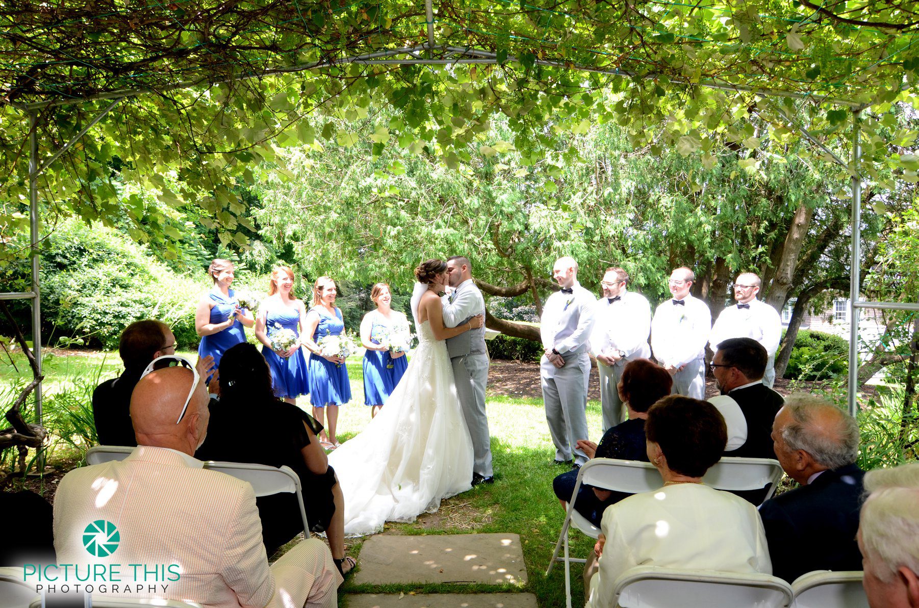 late-june-wedding-ceremony-ends-with-newlyweds-kissing