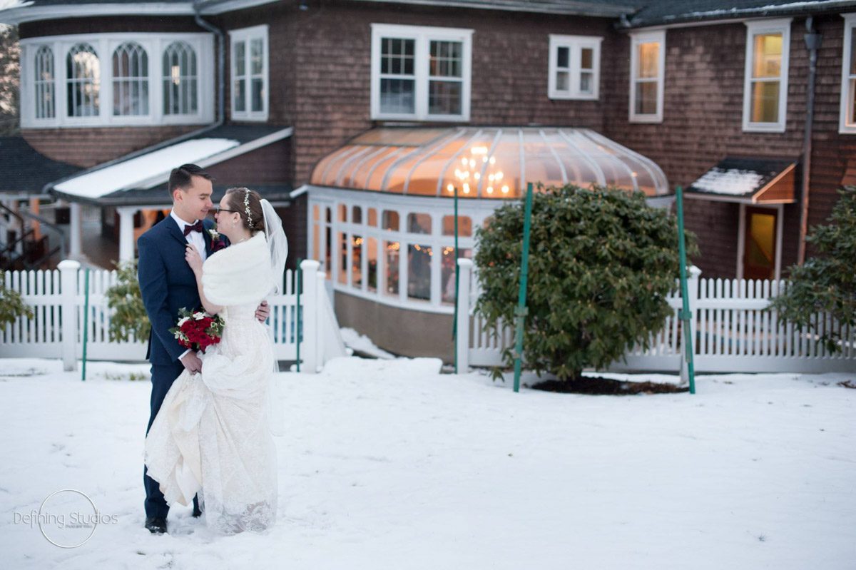 christmas-wedding-couple-standing-close-together-with-mansion-as-background