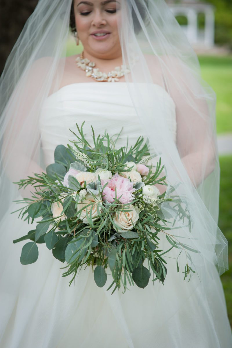 dana in her wedding dress holding a pink and white bouquet