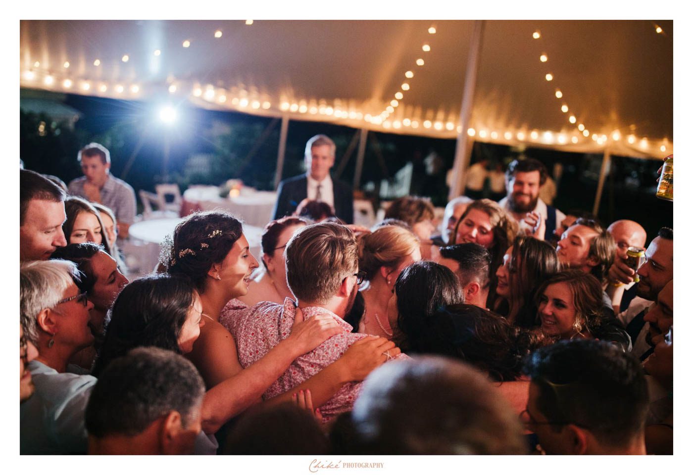 college grads surrounded by family on dance floor
